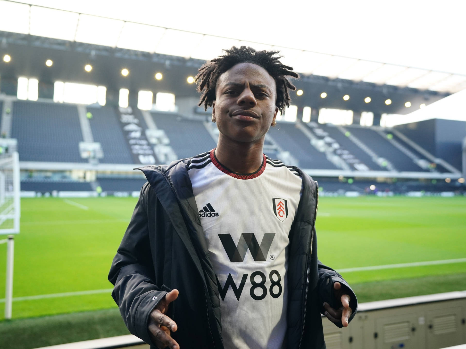 A Young Man Standing In Front Of A Stadium