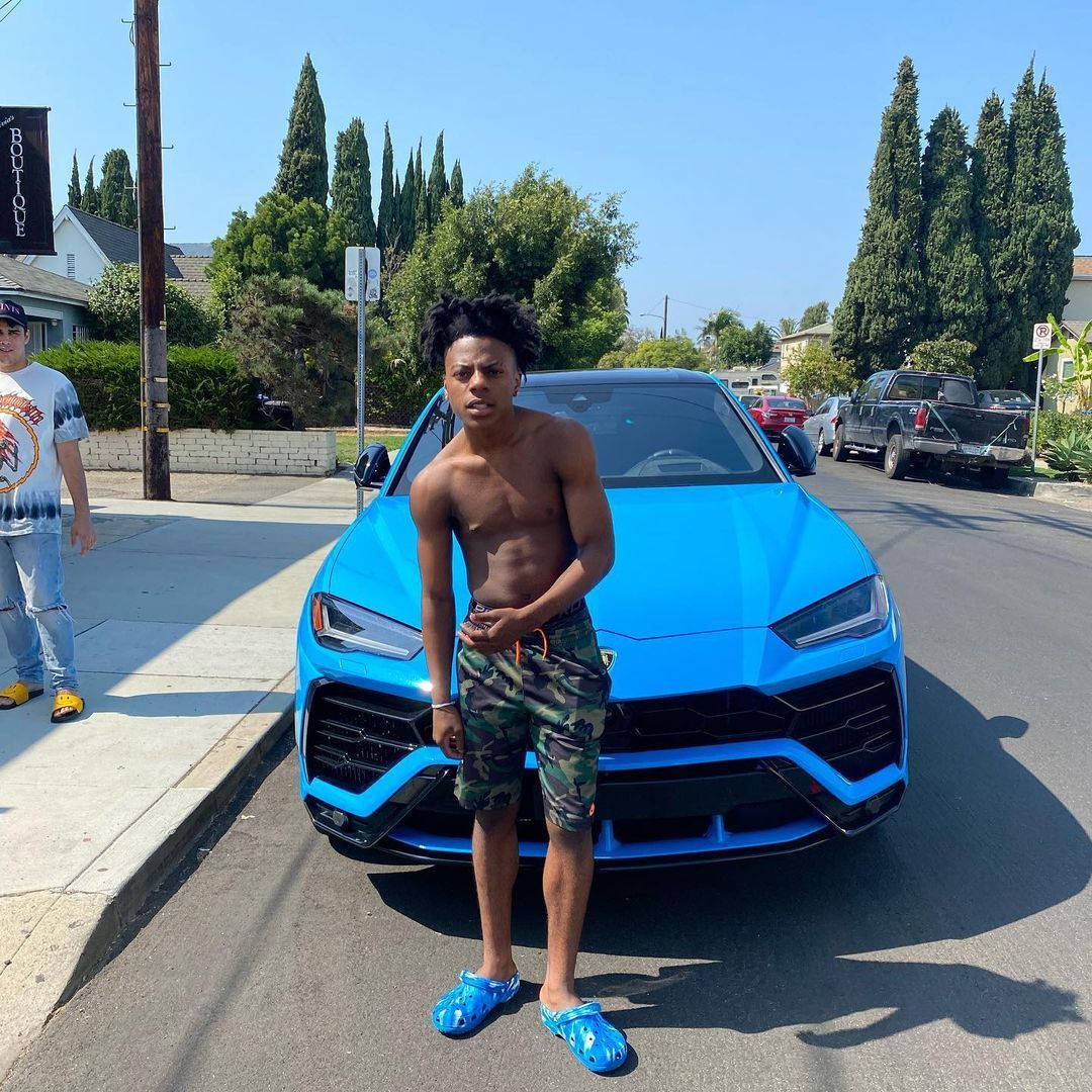 A Young Man Standing Next To A Blue Lamborghini Urus