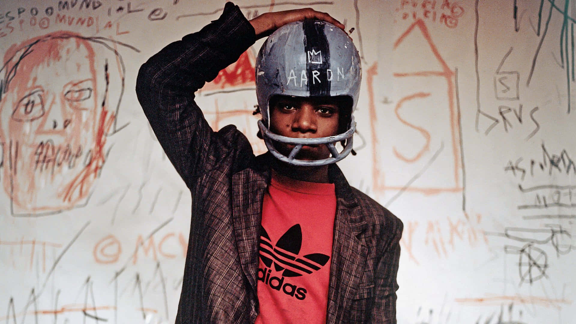 A Young Man Wearing A Helmet And Holding A Football Background