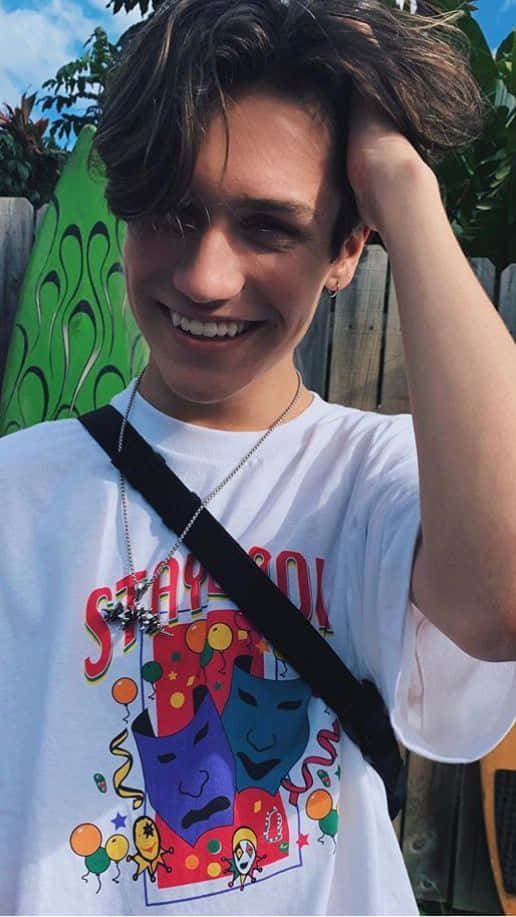 A Young Man Wearing A T - Shirt With A Cartoon Character On It Background