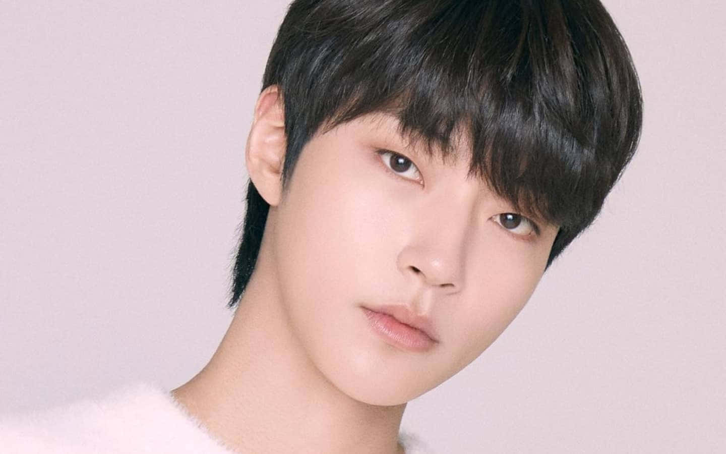 A Young Man With A Black Hair And A White Sweater Background