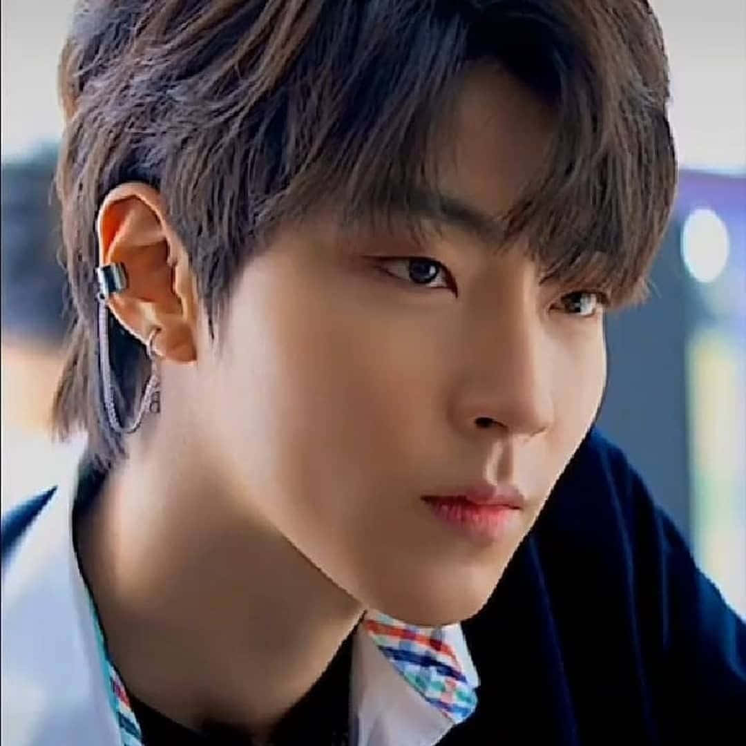 A Young Man With A Black Shirt And Ear Piercings Background