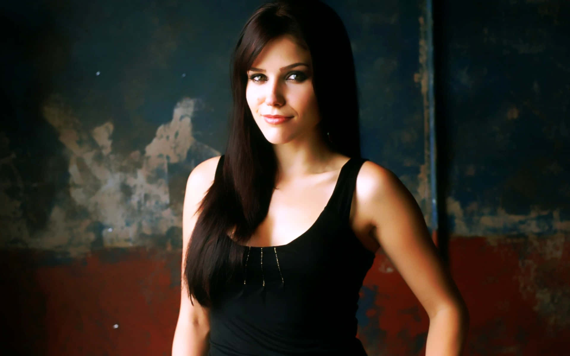 A Young Woman In A Black Top Posing Background