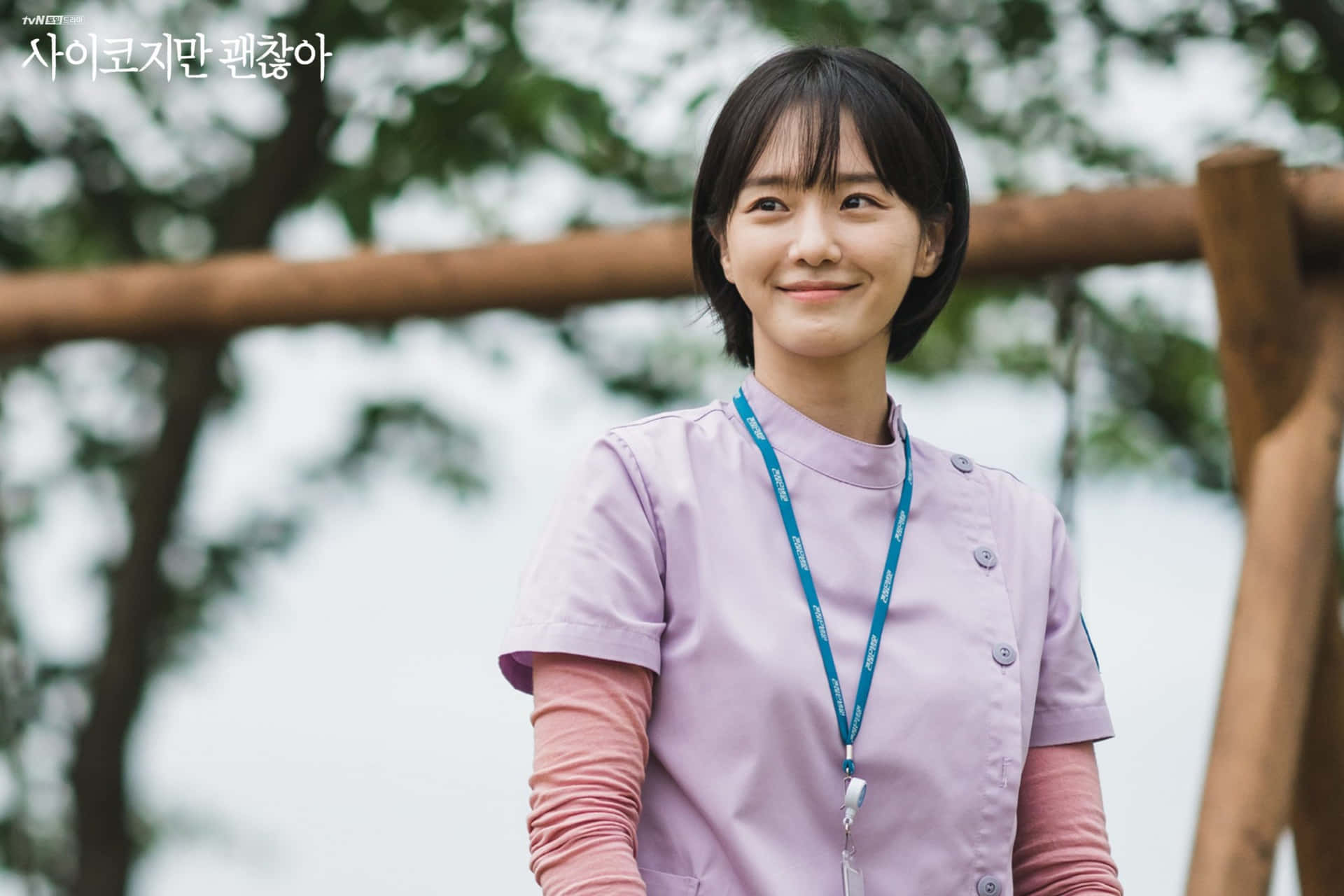 A Young Woman In A Purple Uniform Standing On A Wooden Bench Background