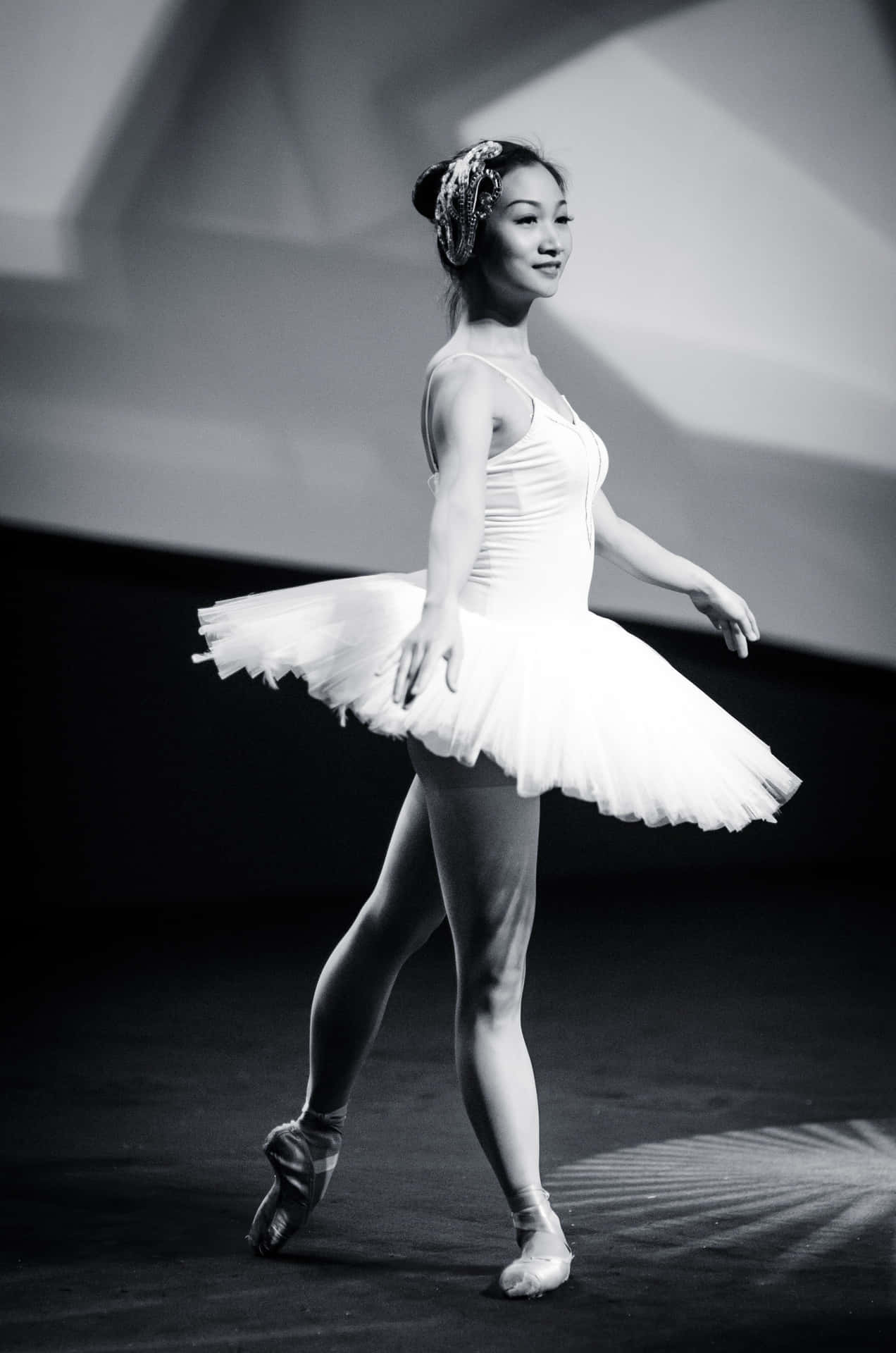 A Young Woman In A White Tutu Is Performing Background
