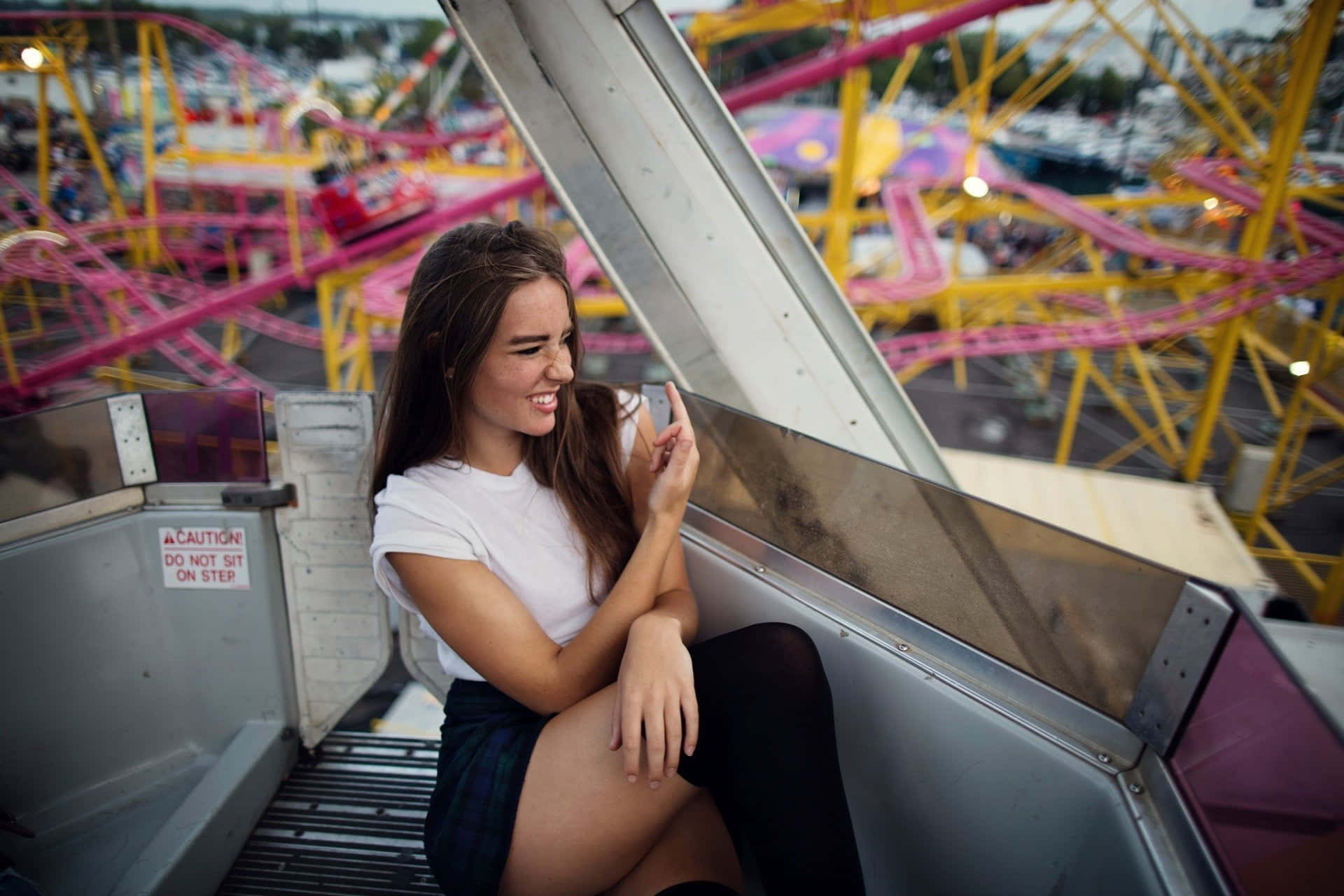 A Young Woman Sitting On A Ferris Wheel Background