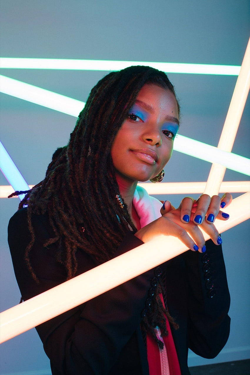 A Young Woman With Dreadlocks Holding Up Neon Lights Background