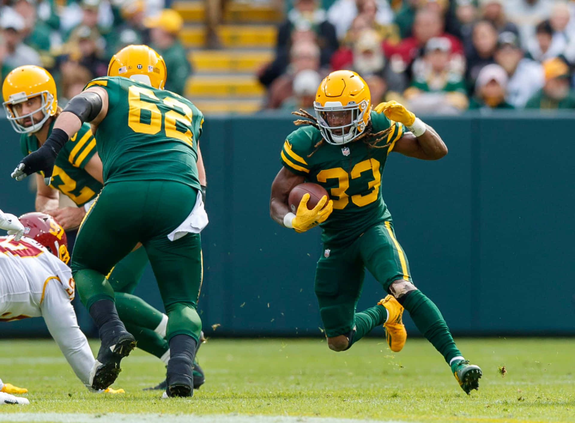 Aaron Jones Of The Green Bay Packers Running The Ball Down The Field. Background