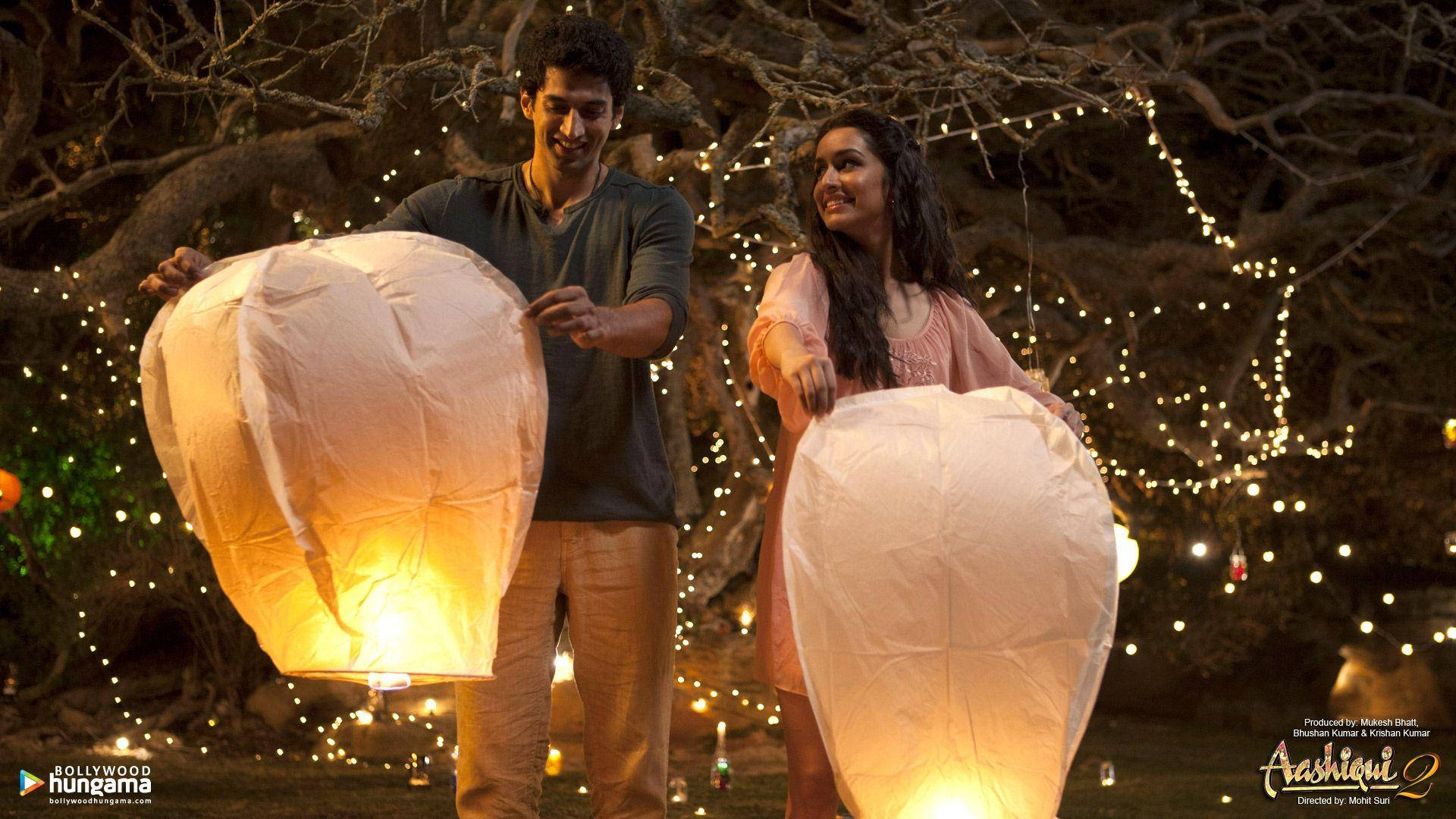 Aashiqui 2 Leading Characters And Lanterns Background