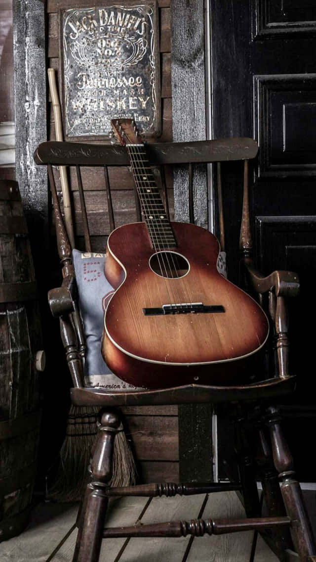 Acoustic Guitar On Rocking Chair Background