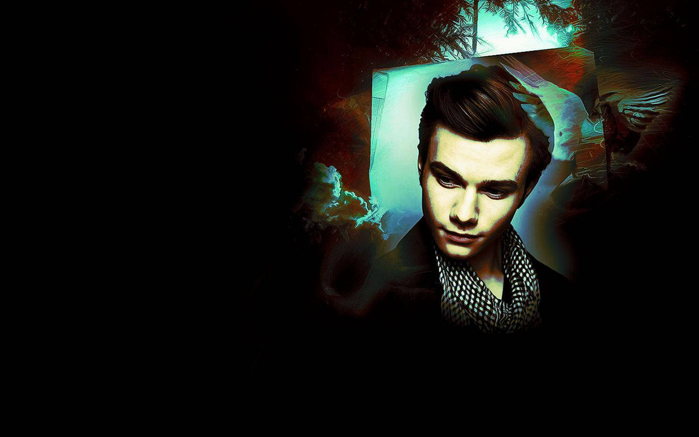 Actor Chris Colfer In Dramatic Lighting Background