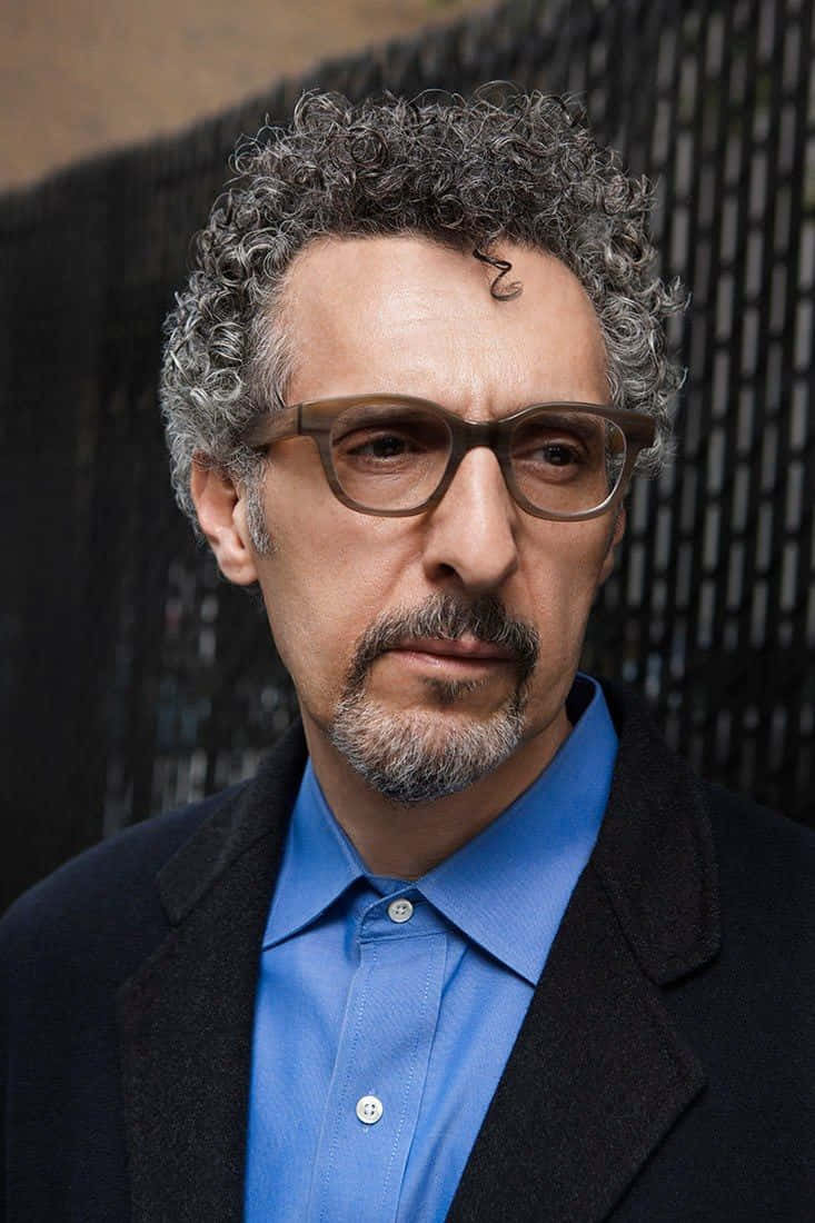 Actor John Turturro Dressed In A Classic Suit And Tie. Background