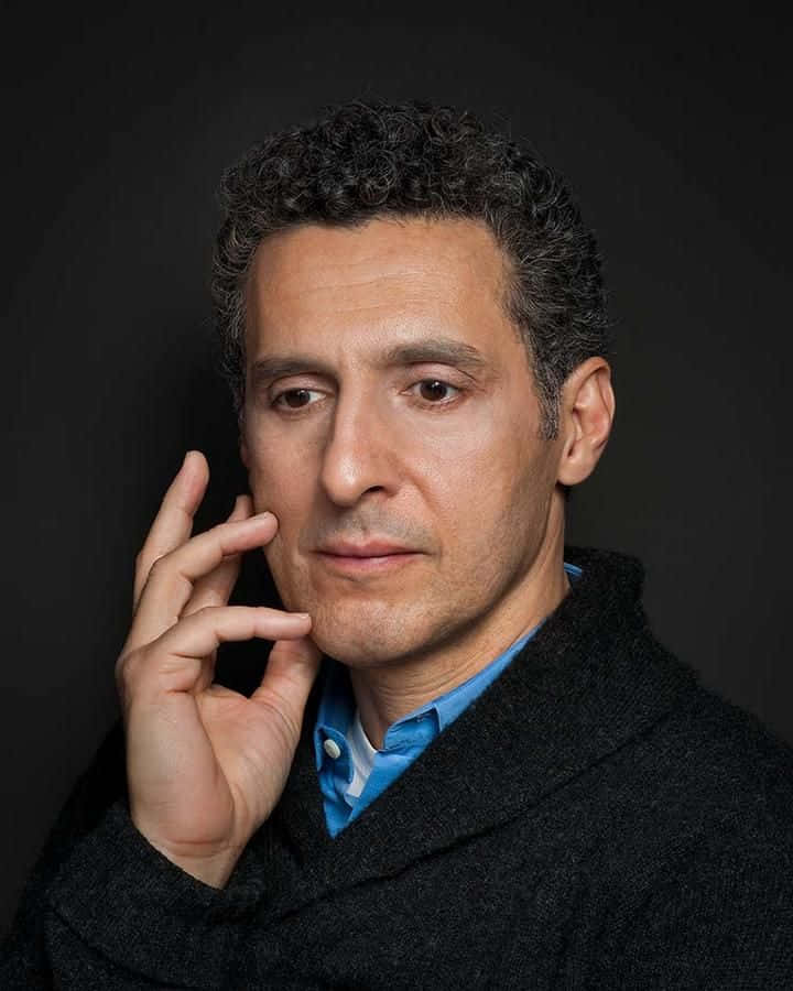 Actor John Turturro Enjoying A Laugh Background