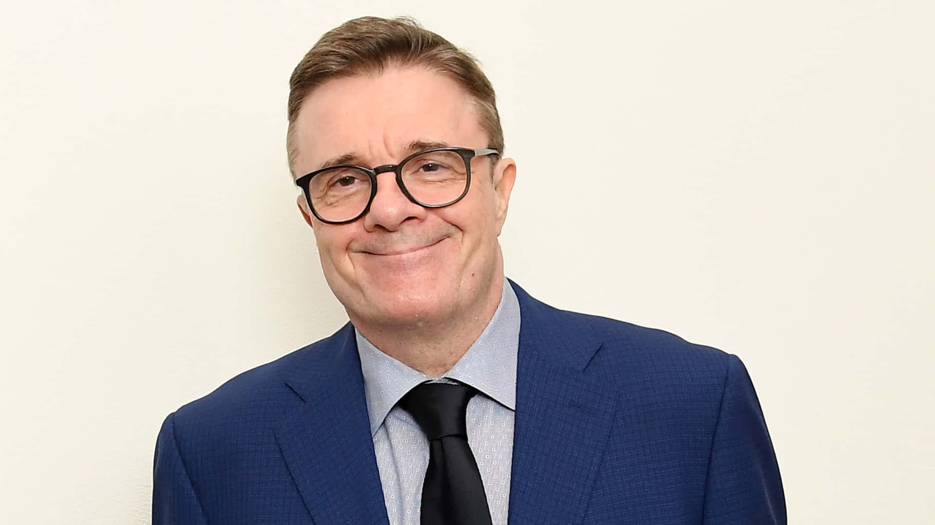 Actor Nathan Lane Wearing A Suit And Red Tie