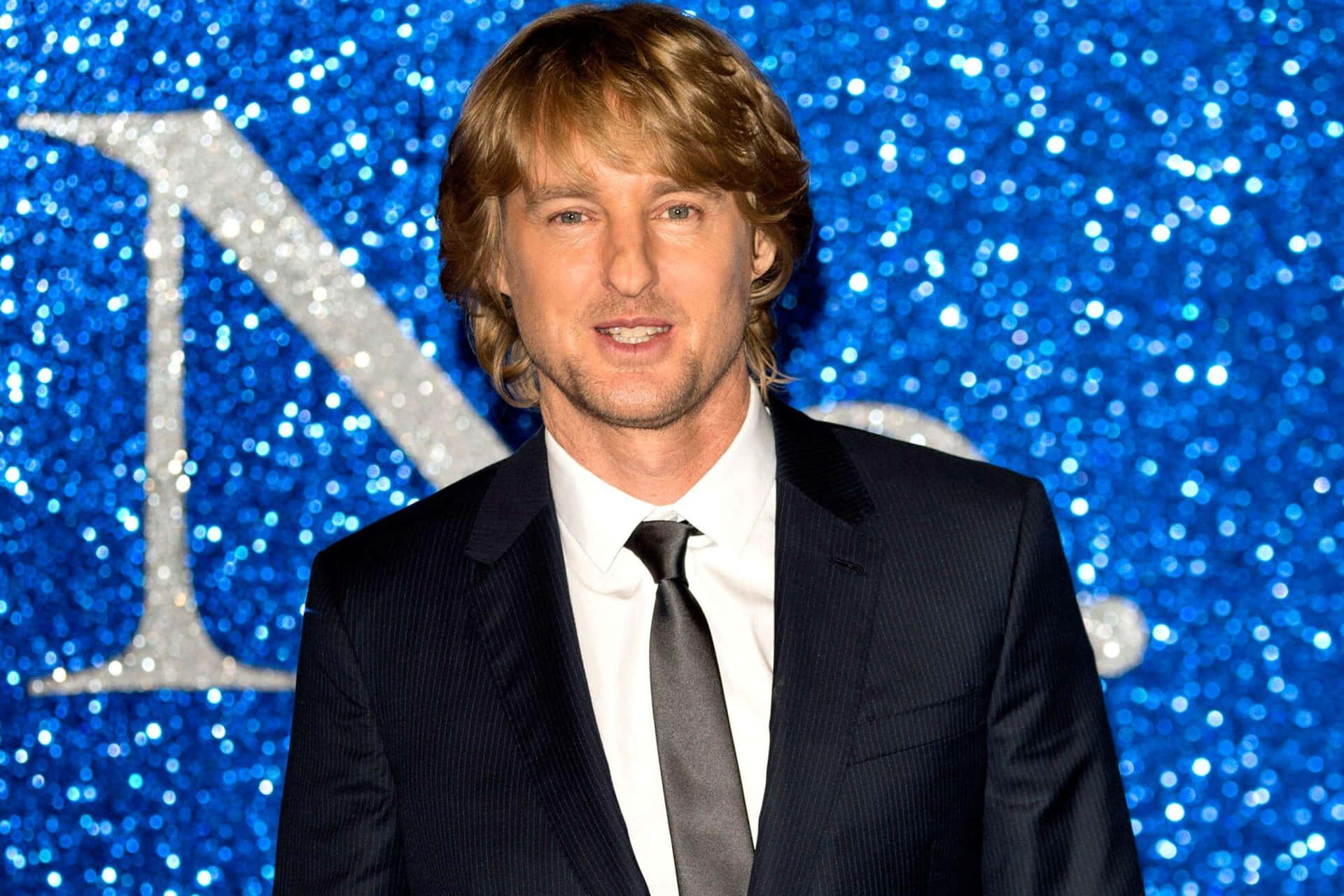 Actor Owen Wilson Strikes A Dashing Pose. Background