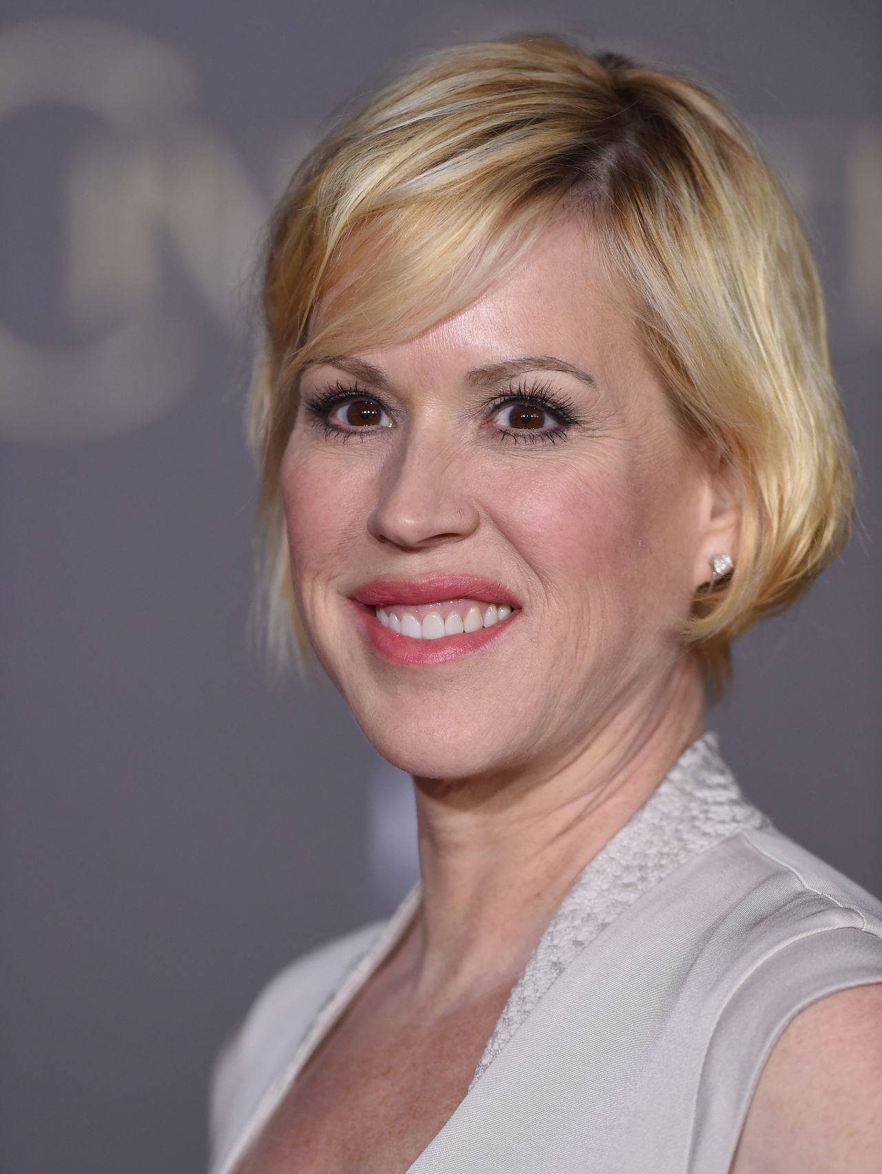 Actress Molly Ringwald With Blonde Pixie Hairstyle Background