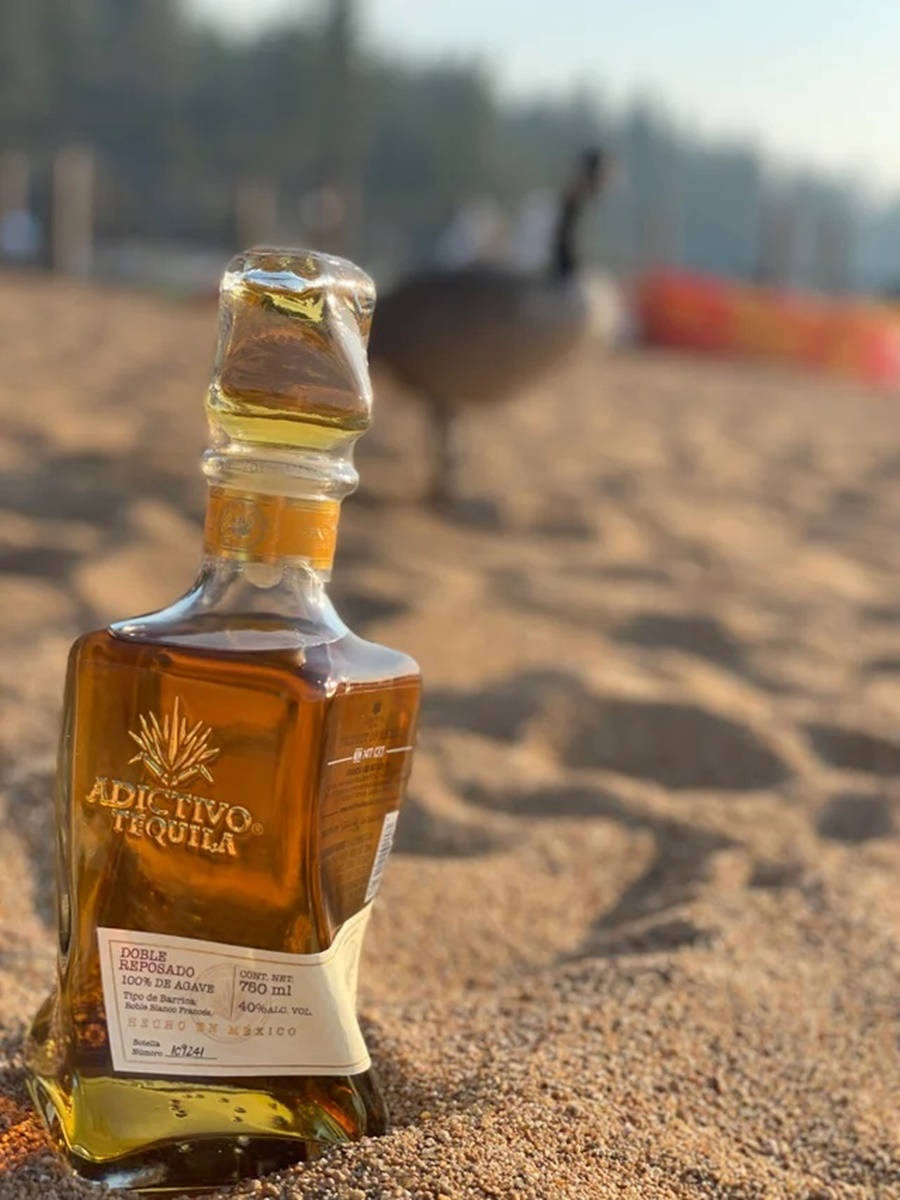 Adictivo Tequila Relaxing On The Beach Background