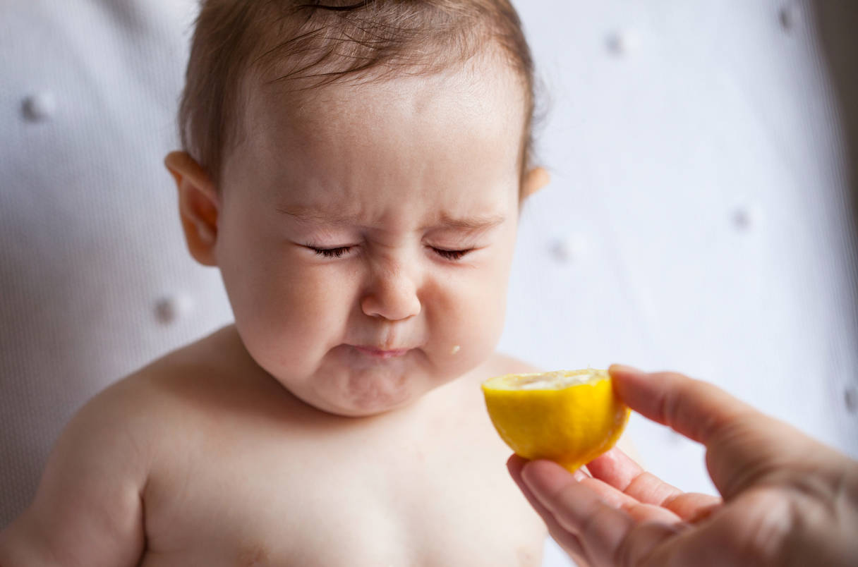 Adorable Baby Experiencing Sour Lemon Background