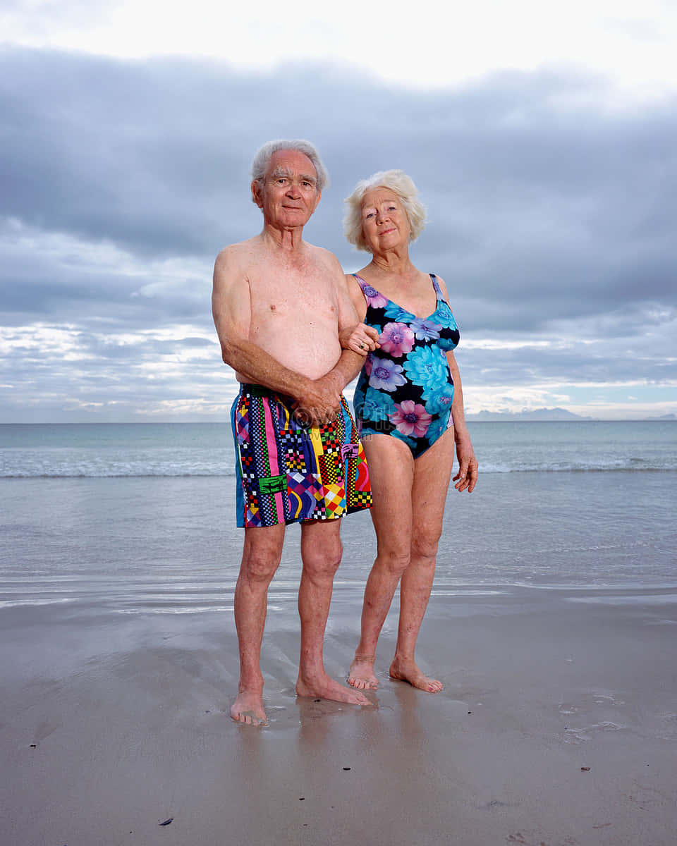 Adorable Elderly Couple At Beach Background