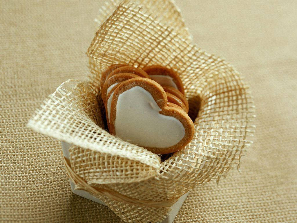 Adorable Heart-shaped Cookies Nestled In A Basket Background