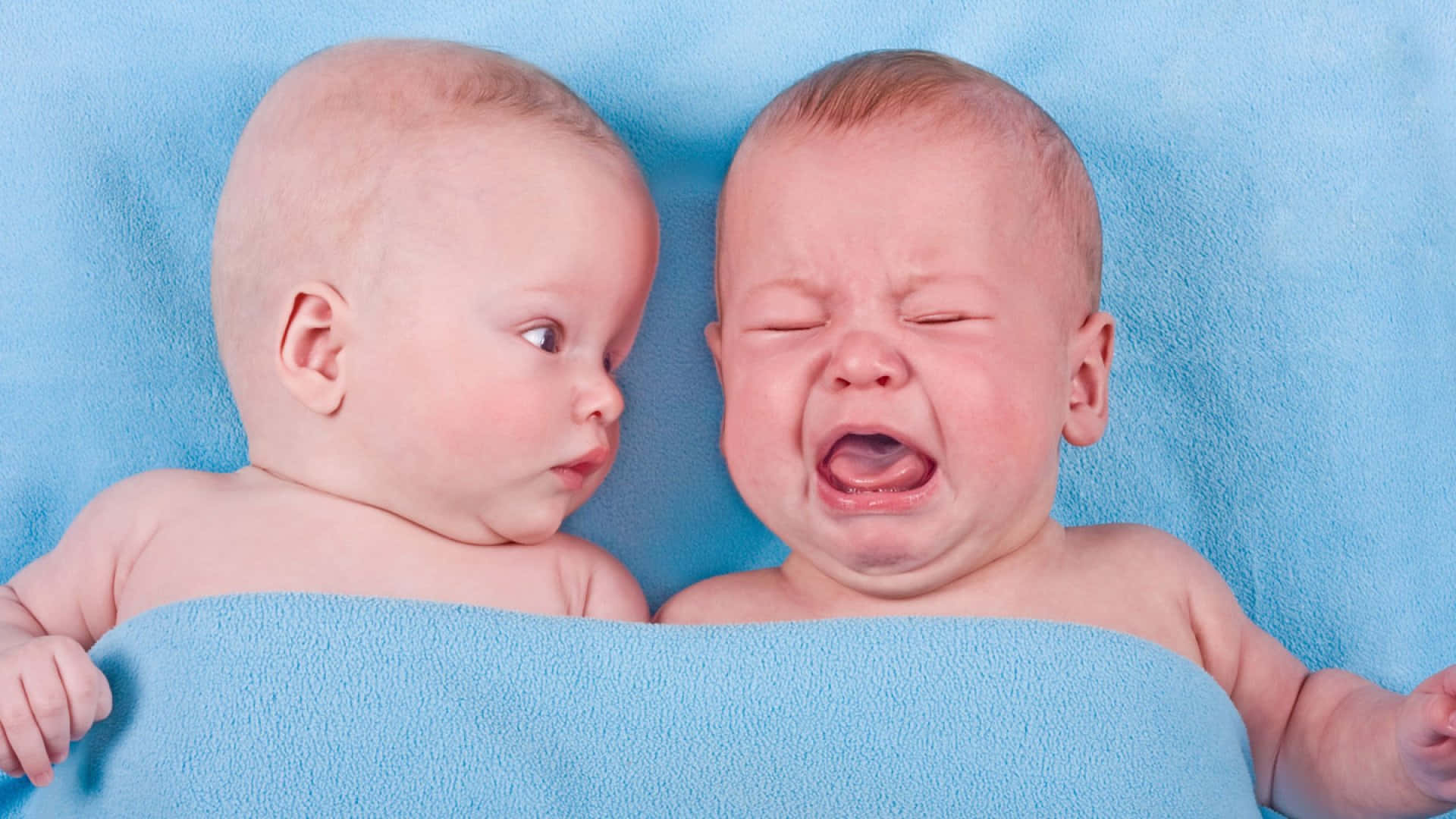 Adorable Twin Babies Displaying Discontent Background