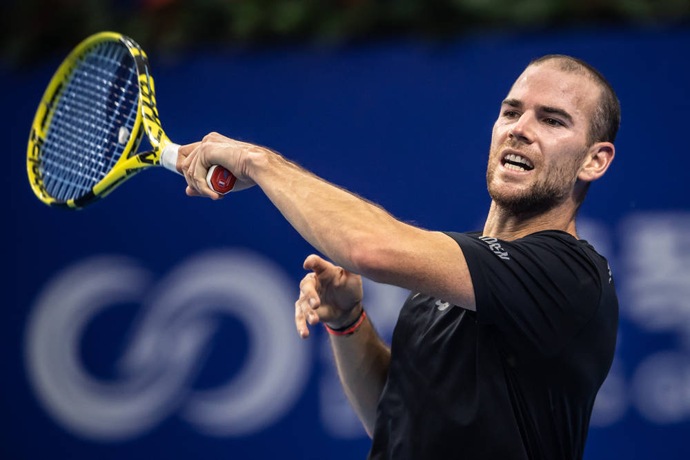 Adrian Mannarino Executing A Forehand Stroke In A Tennis Match. Background