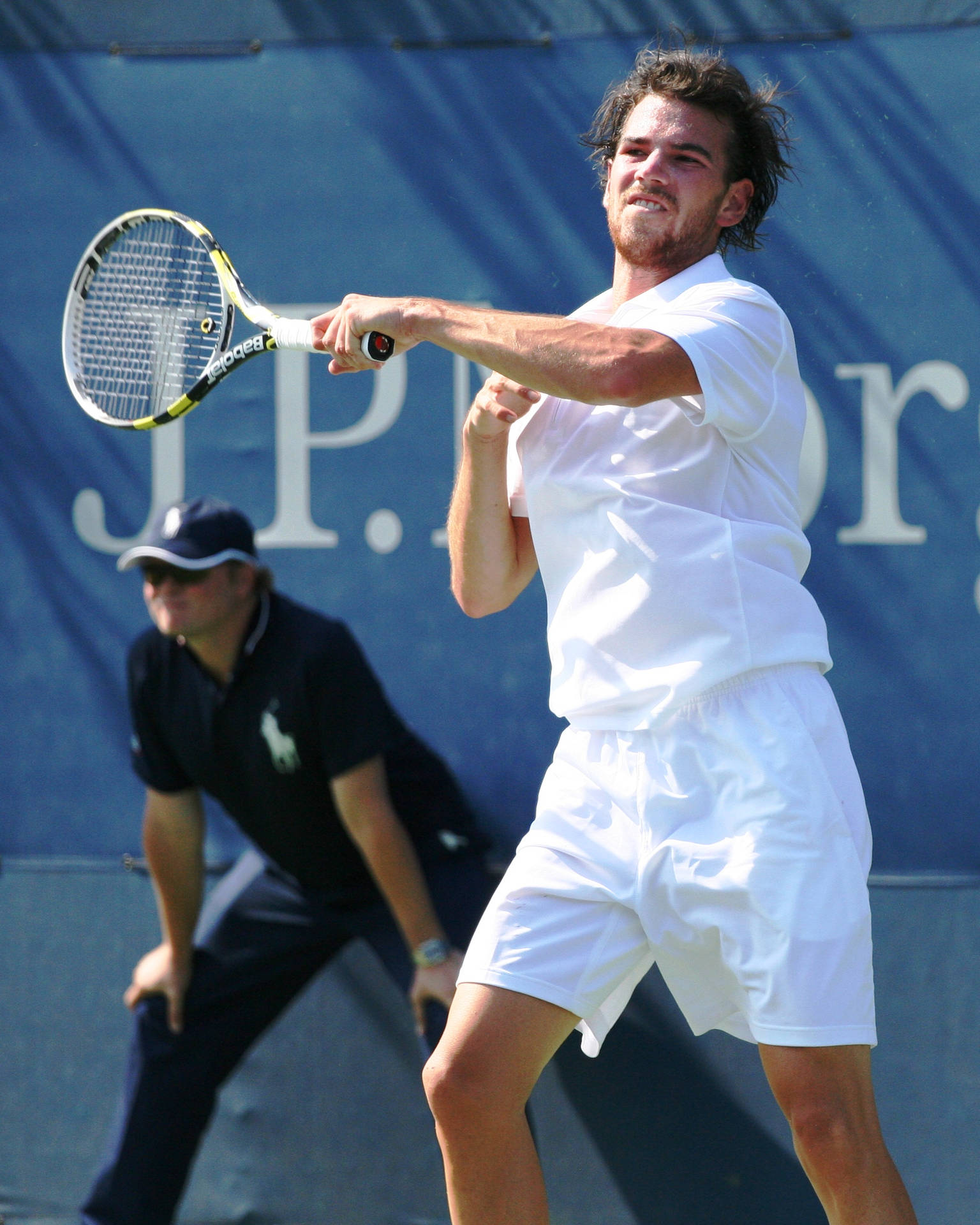 Adrian Mannarino Executing A Powerful Backhand Shot In A Tennis Match Background