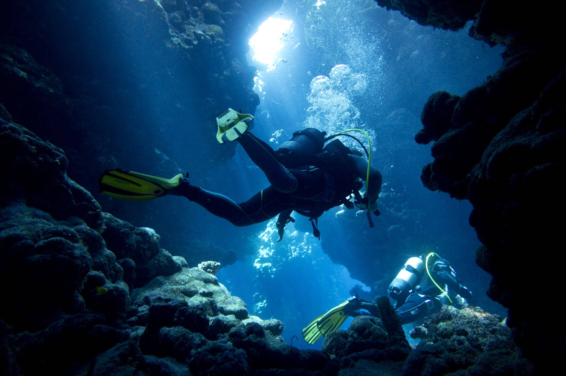 Adventurous Scuba Diving In Mesmerizing Underwater Cavern Background