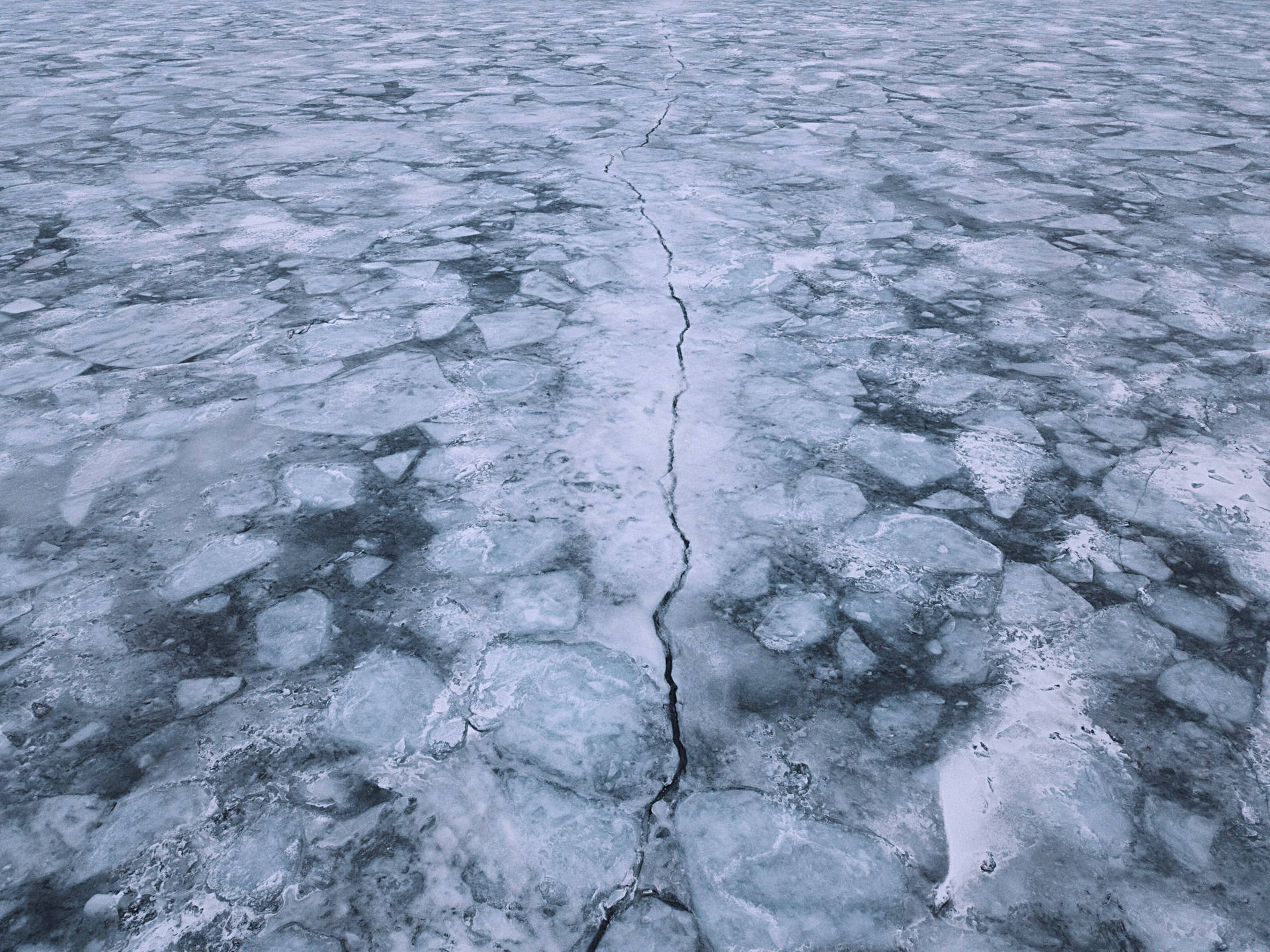 Aerial View Of Cracked Ice Lake Background