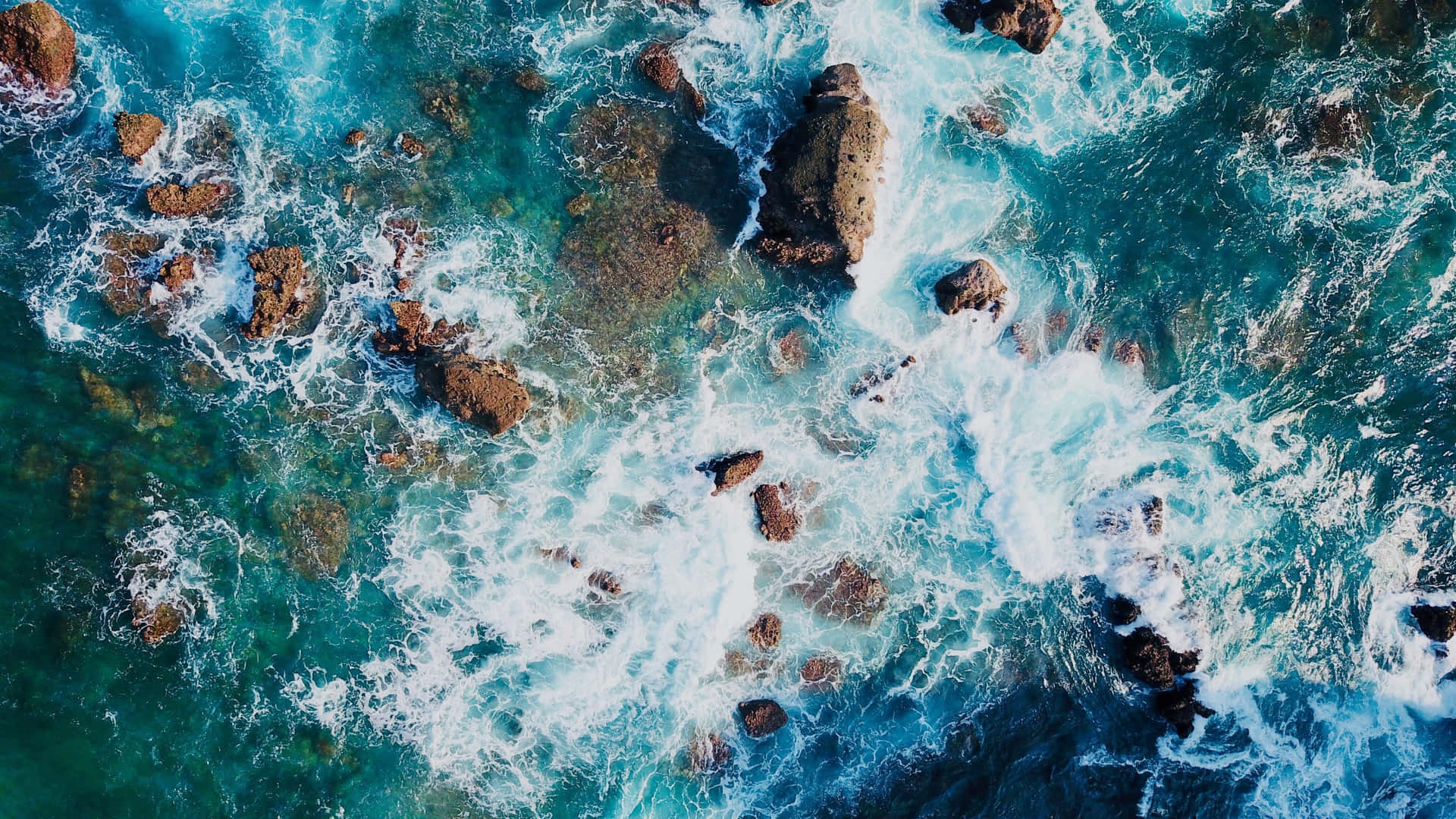 Aerial View Of Ocean Waves Crashing On Rocks