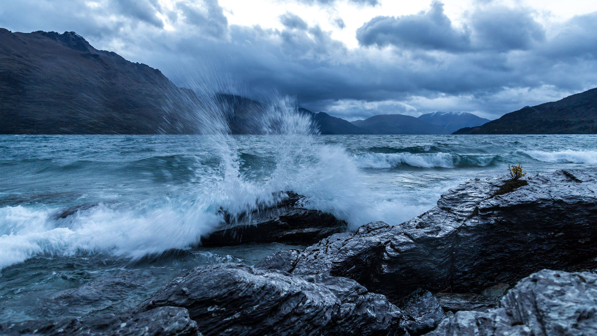 Aesthetic Fury Of Ocean Waves Crashing Over Rocky Coastline Background