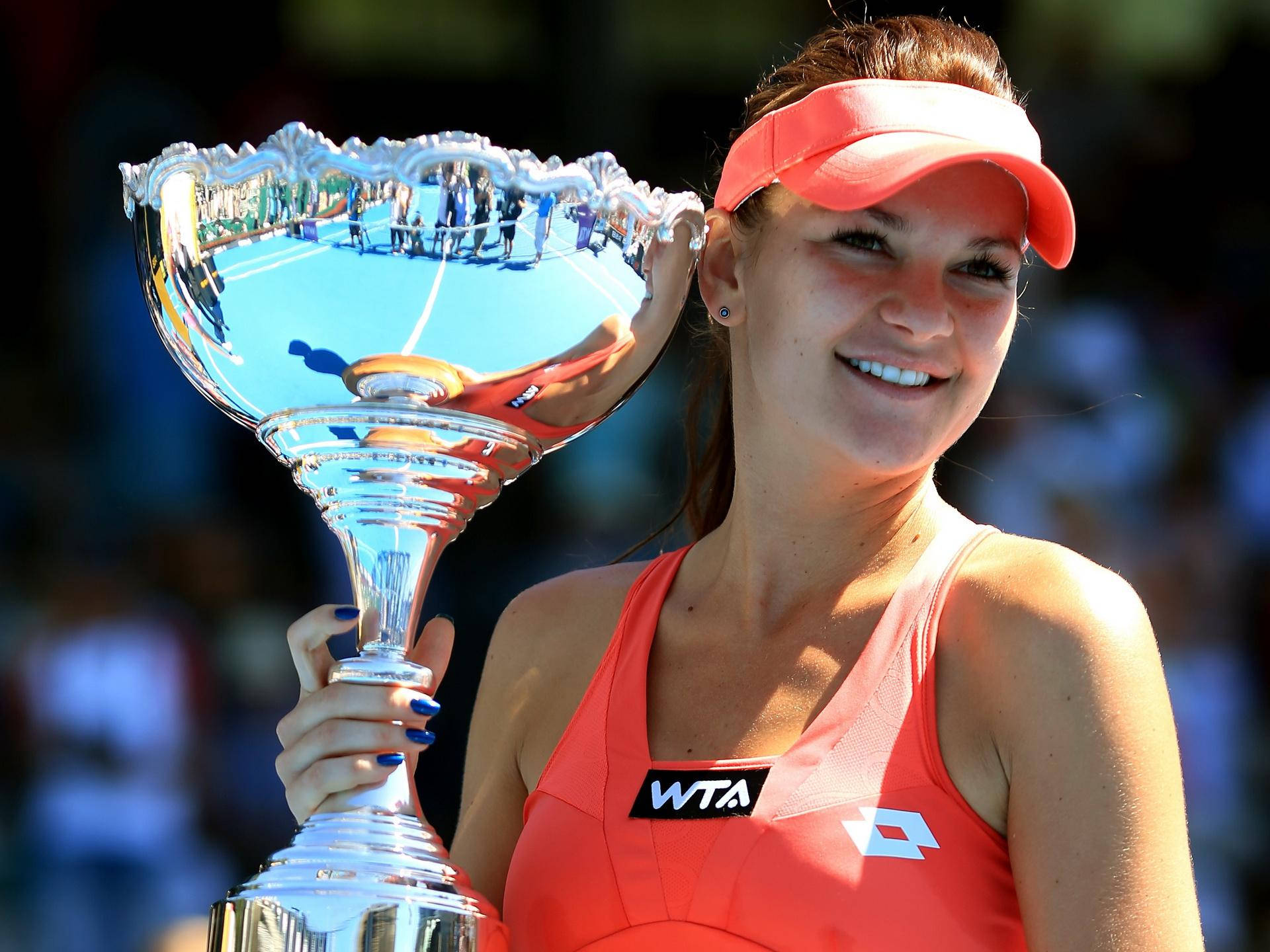 Agnieszka Radwanska Holding A Trophy Up Background