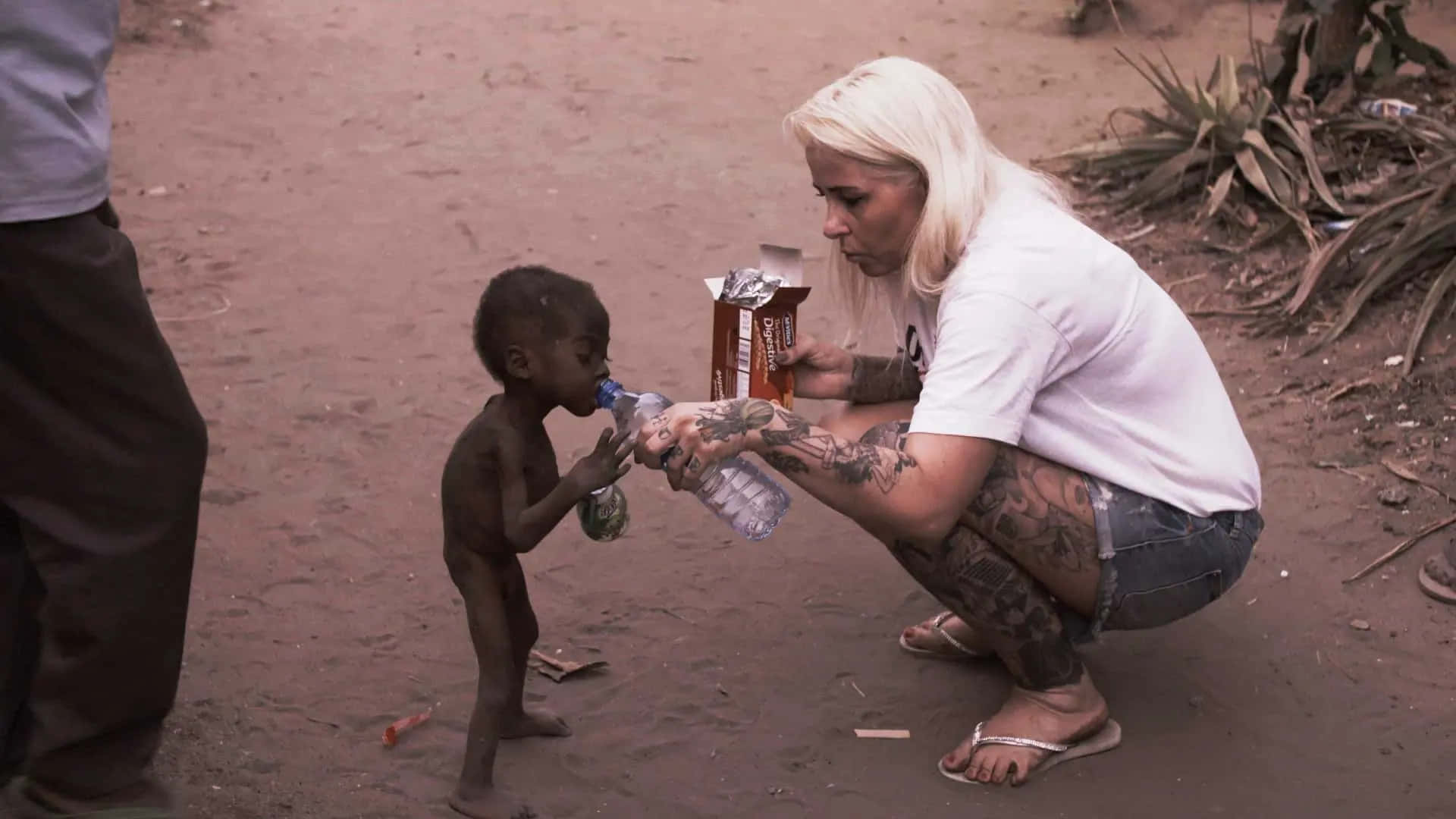 Aid Worker Quenching The Thirst Of An Emaciated Child Background