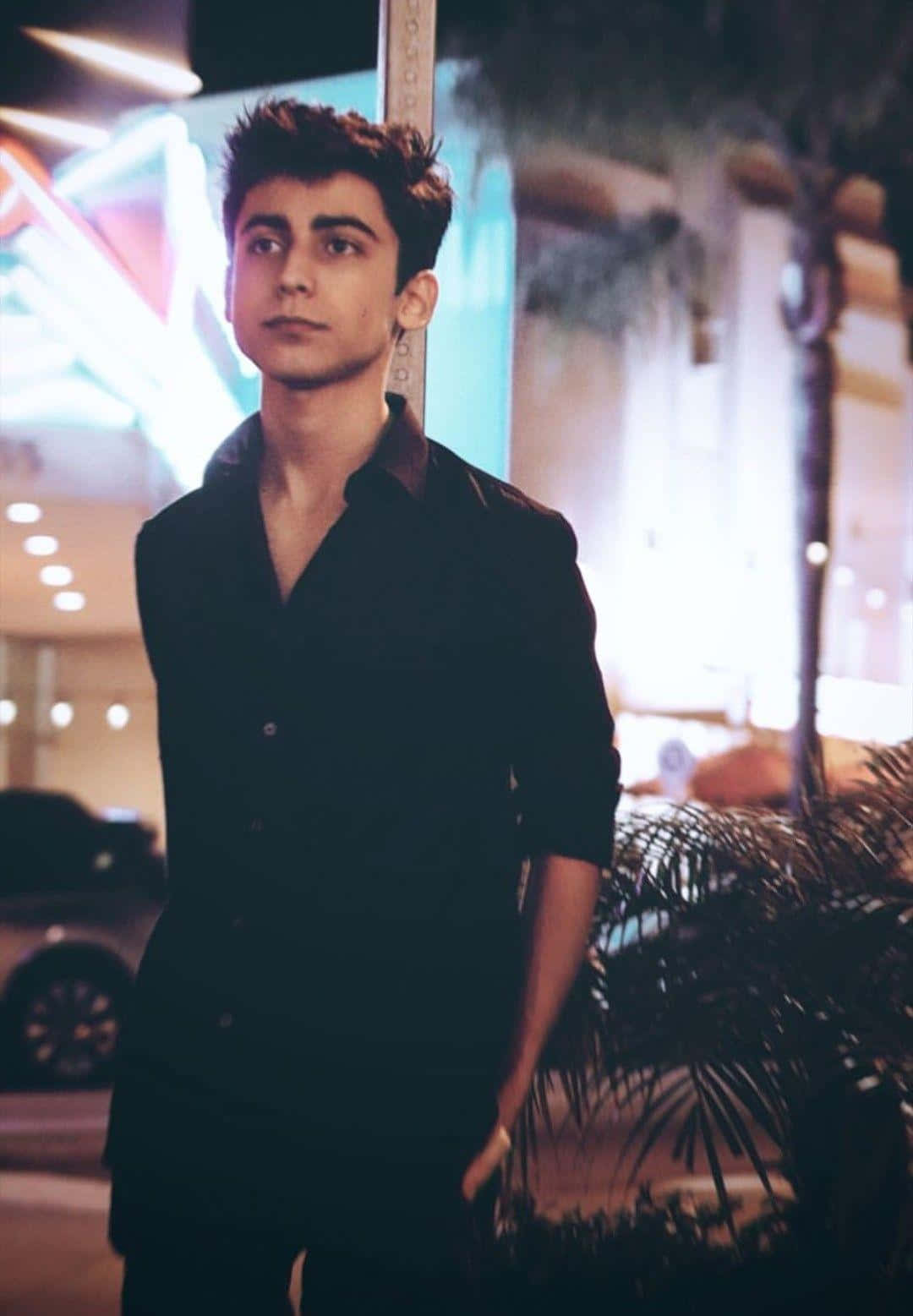 Aidan Gallagher Striking A Superhero Pose Background