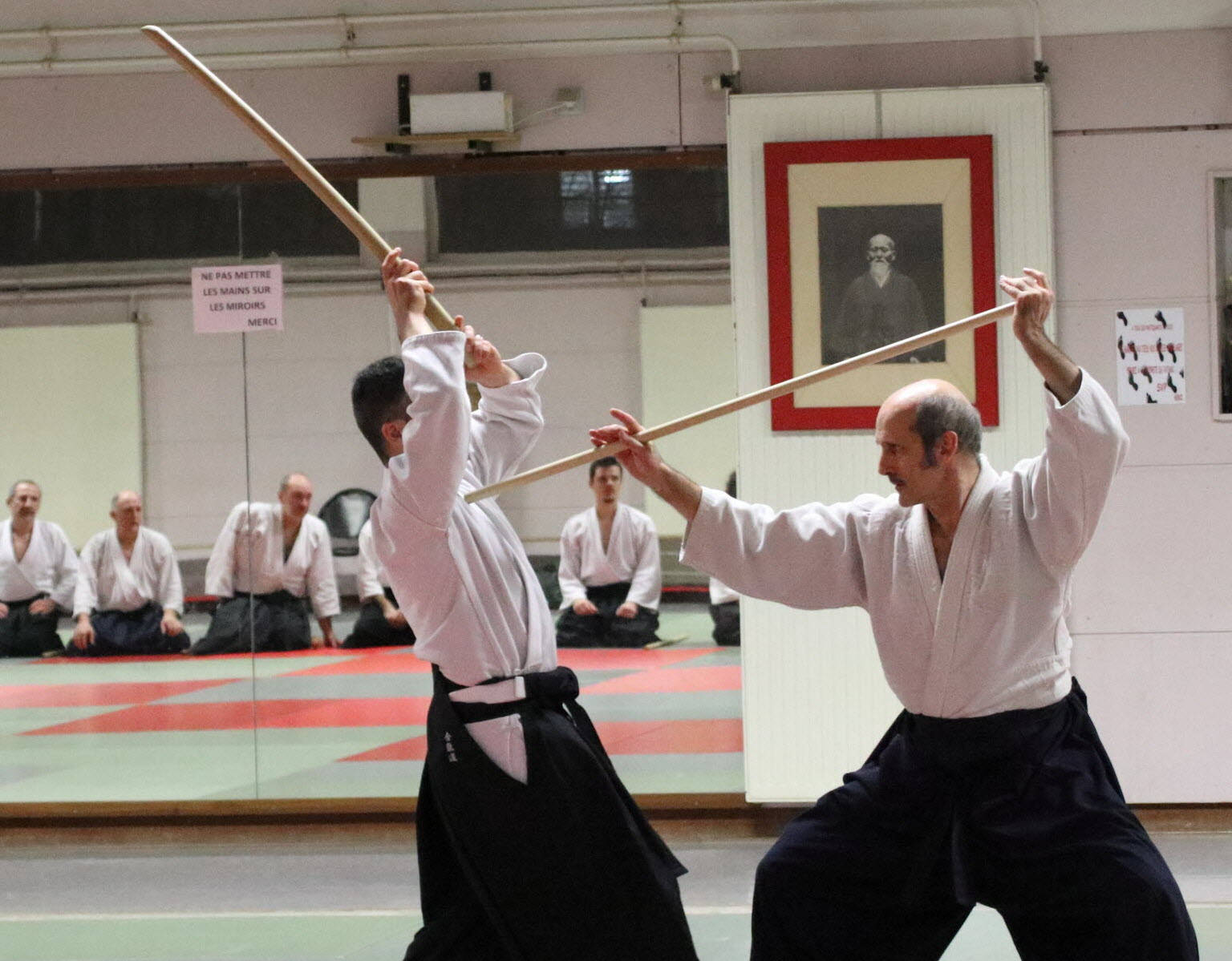 Aikido Master Practicing With Jo Staff In Traditional Dojo Background