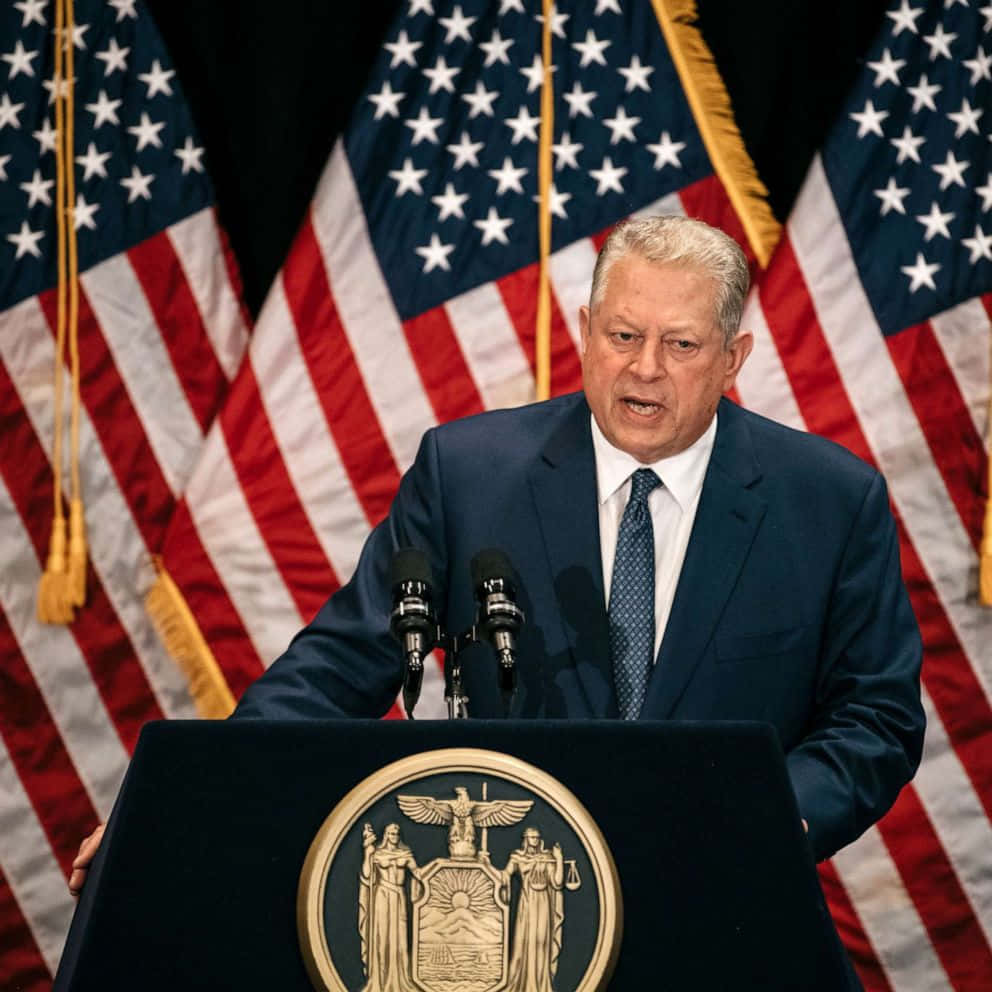Al Gore Delivering A Speech On An American Themed Podium. Background