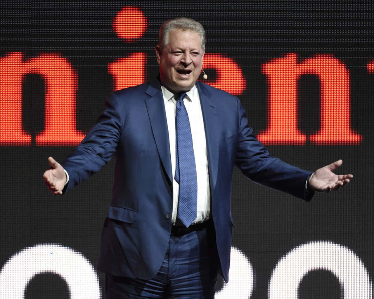 Al Gore Speaking On Stage Background