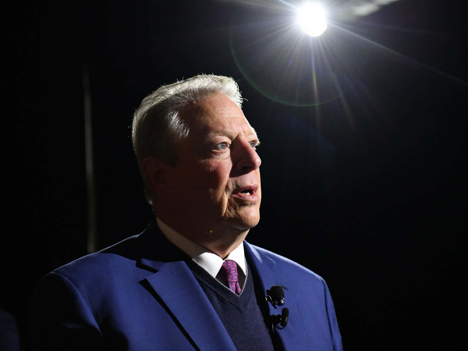 Al Gore Standing Under A Light Background