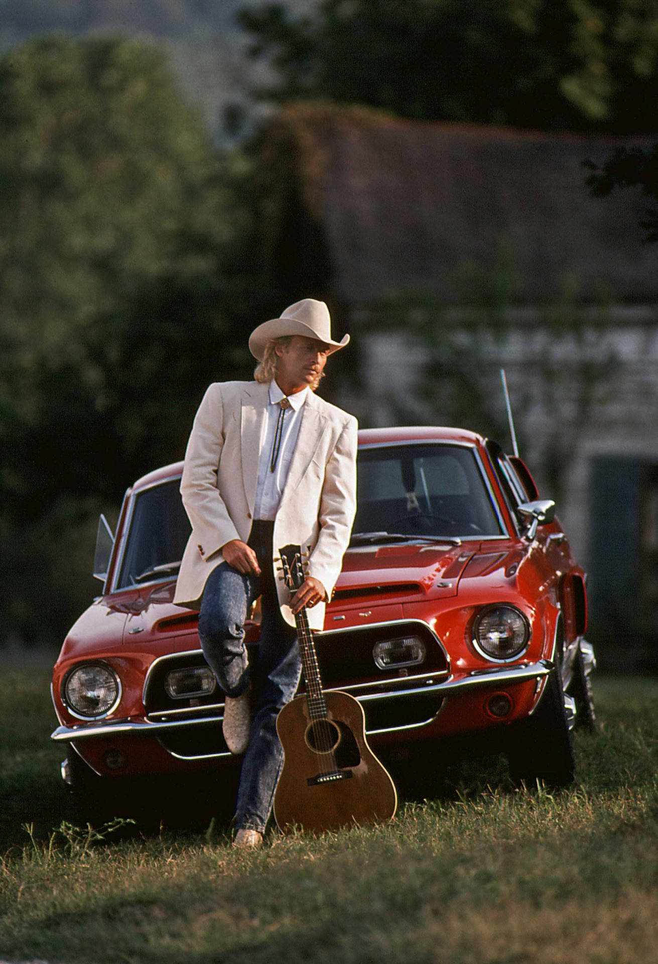 Alan Jackson Leaning Against Red Car Background