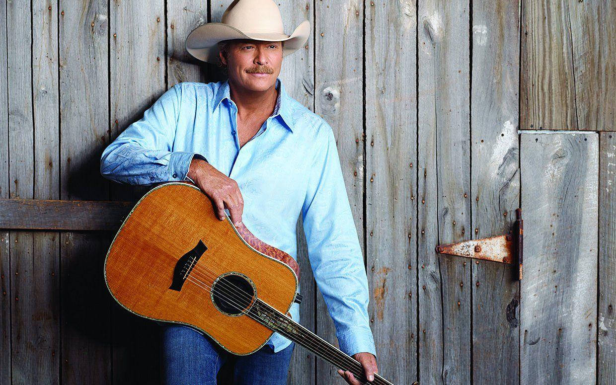 Alan Jackson Standing Against Wooden Wall Background