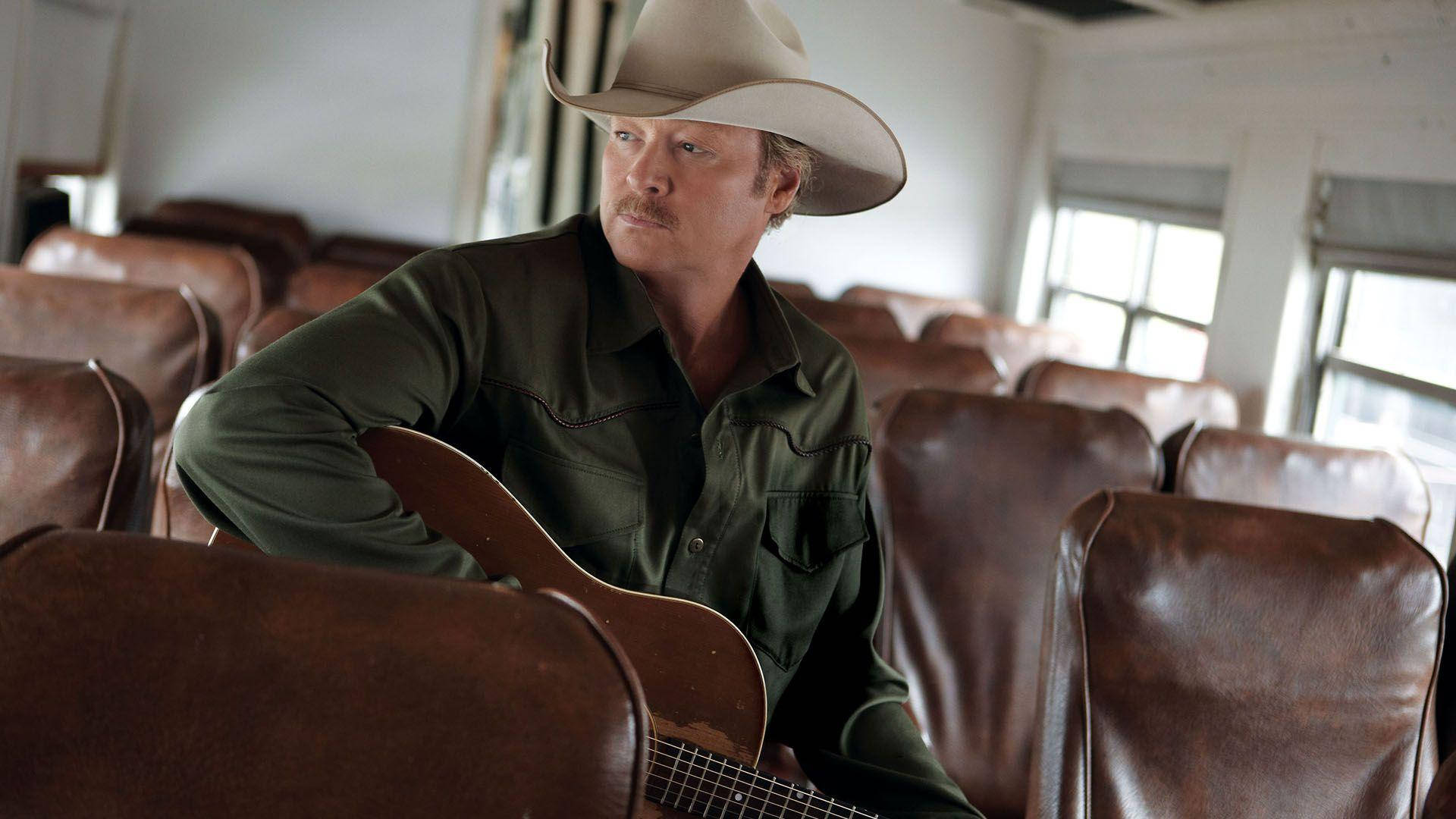 Alan Jackson With Guitar On Bus Background