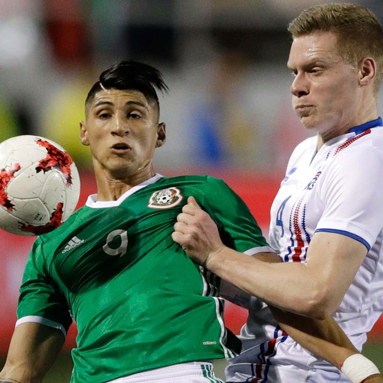 Alan Pulido Challenging The Spain Defender During An International Soccer Match Background