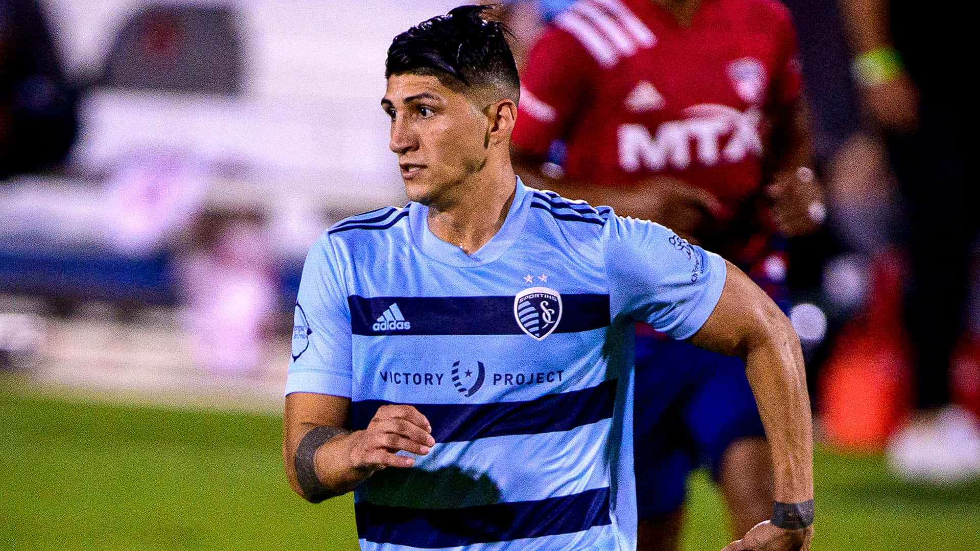 Alan Pulido Striding In The Field Background