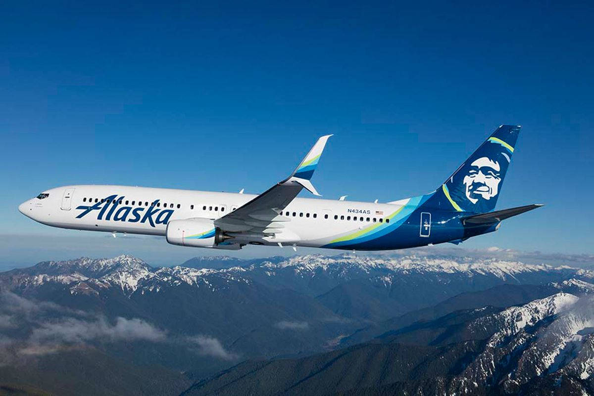 Alaska Airlines Flight Over Scenic Mountain Landscape Background