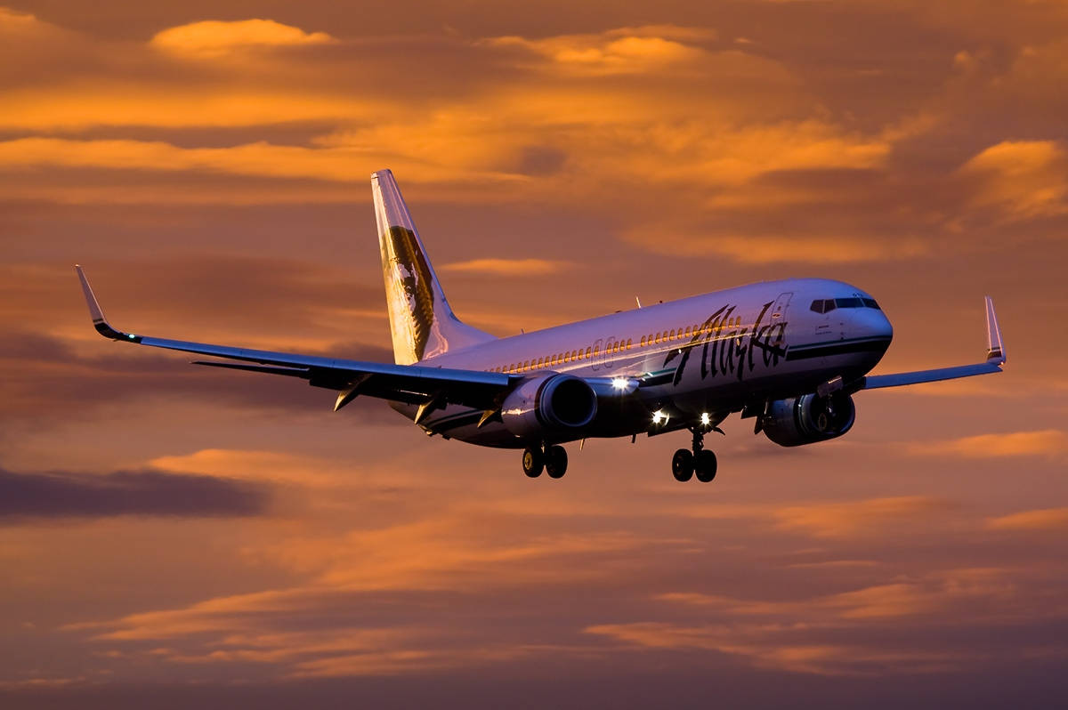 Alaska Airlines Flying On Orange Dusk Skies