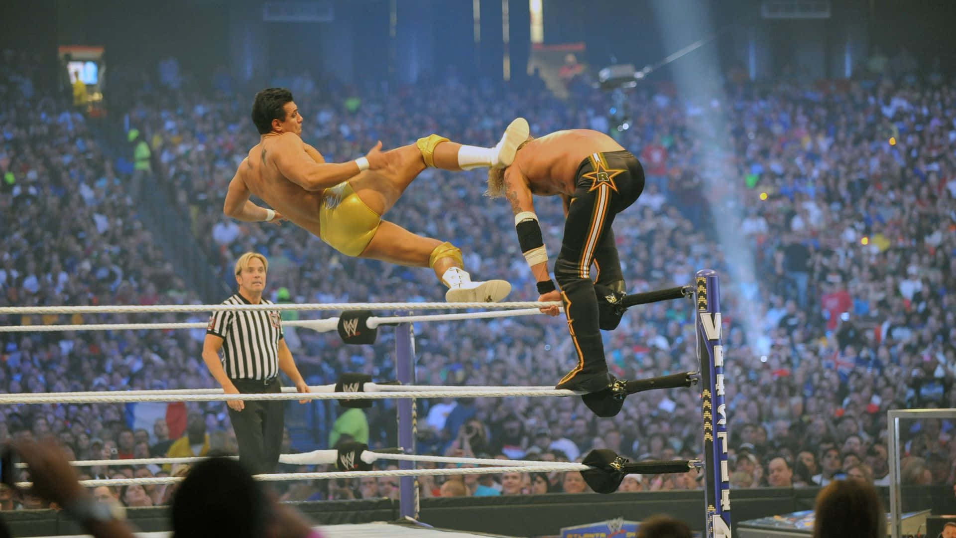 Alberto Del Rio Executing A Dramatic Kick On His Opponent In The Wwe Ring Background