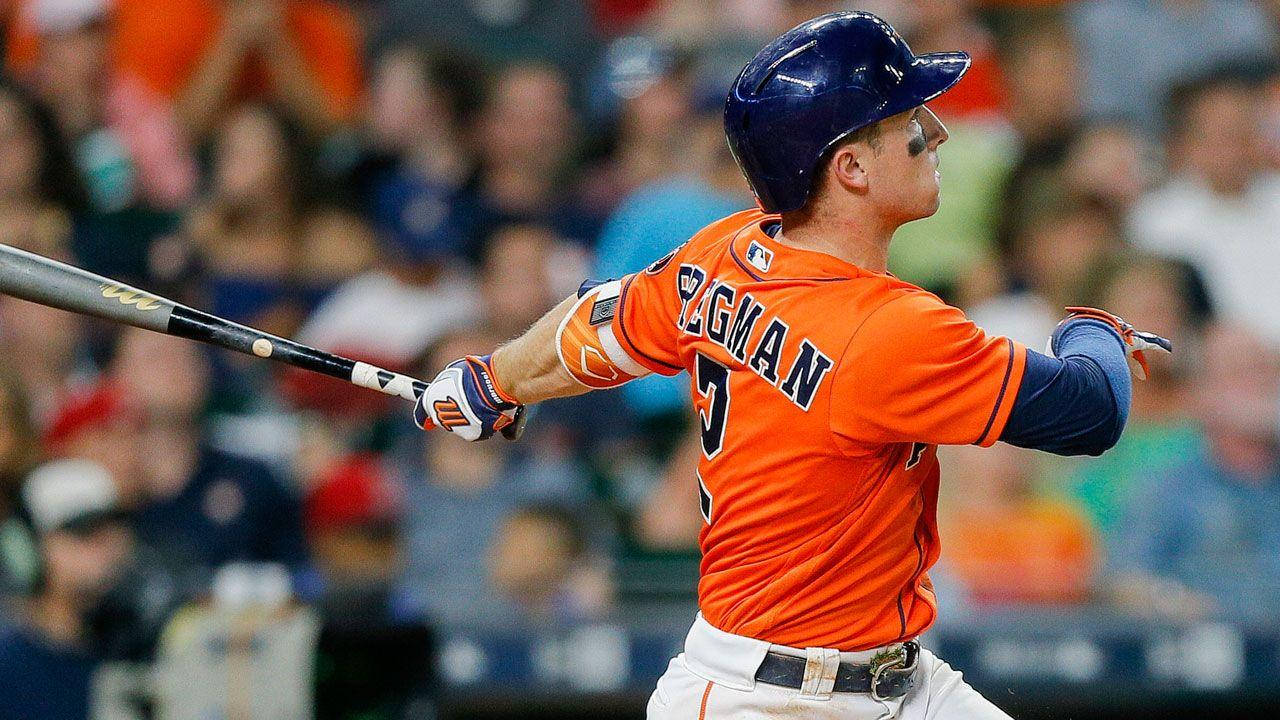 Alex Bregman In Orange Astros Uniform Swinging Bat Background
