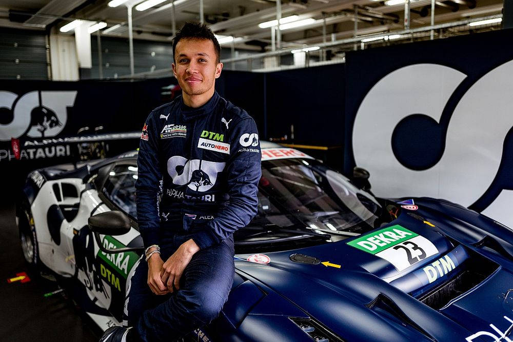 Alexander Albon Sitting On Car Background