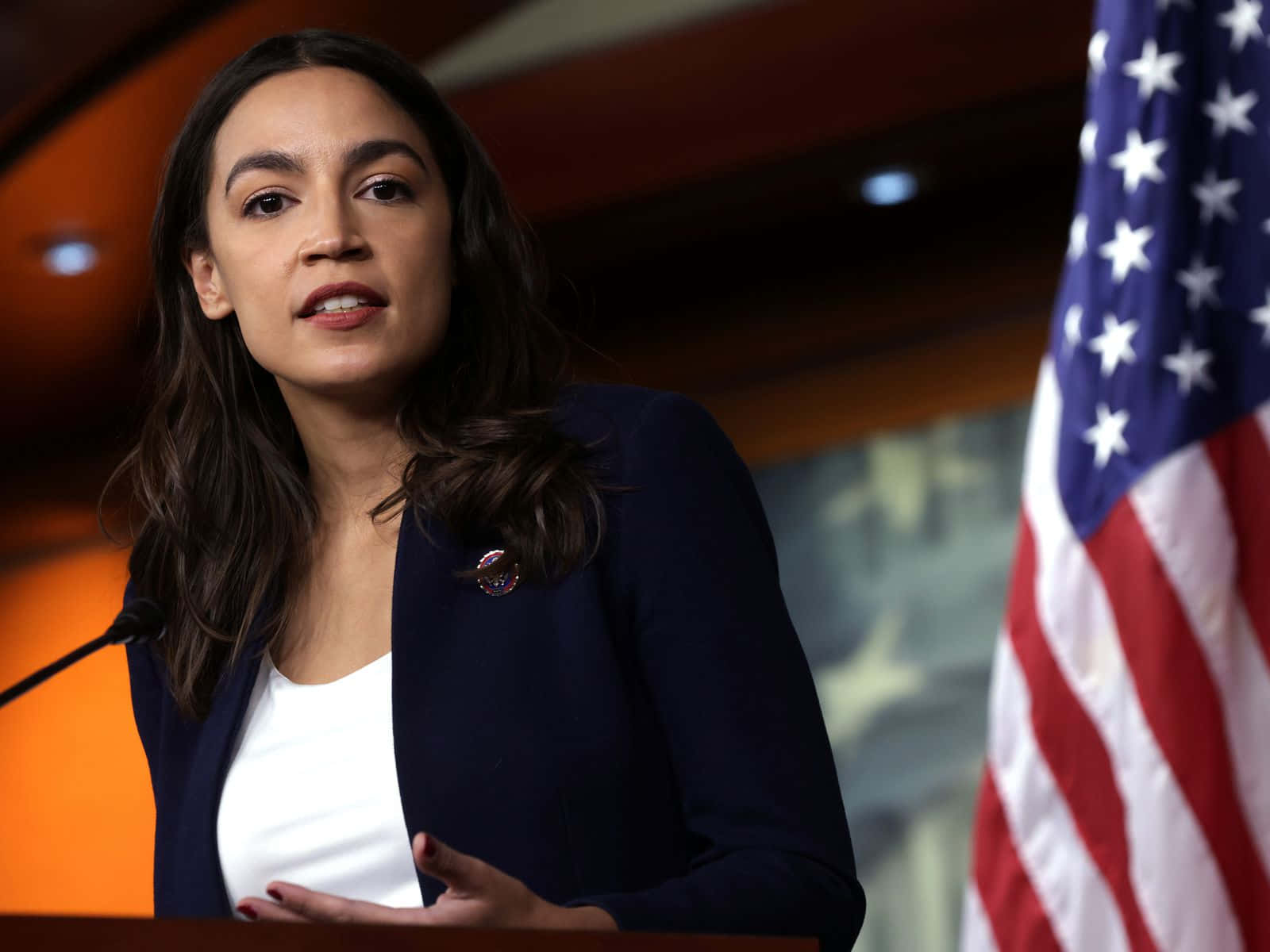 Alexandria Ocasio-cortez Beside American Flag Background