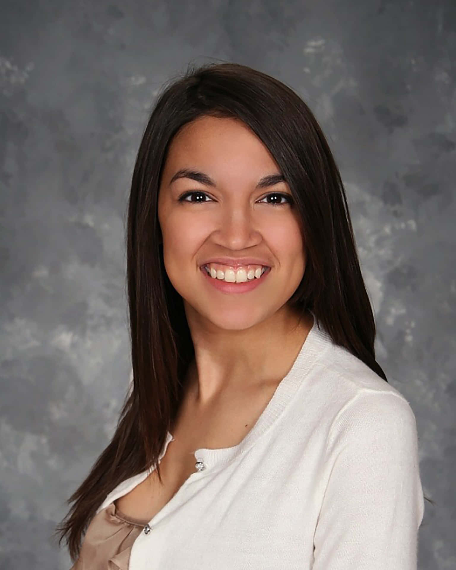 Alexandria Ocasio-cortez Smiling With Gray Backdrop Background